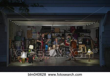 Stock Photo - Caucasian band playing in garage. Fotosearch