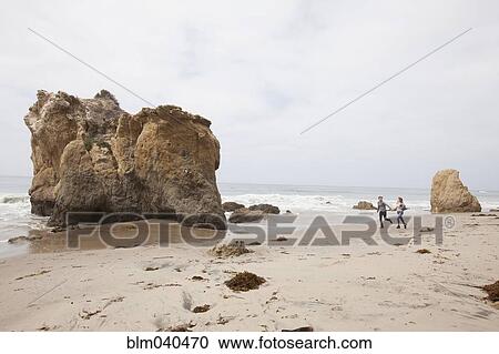 Stock Image - Caucasian couple exploring beach. Fotosearch
