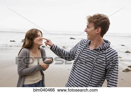 Stock Photograph - Caucasian couple playing on beach. Fotosearch