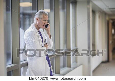 Stock Image - Caucasian doctor talking on cell phone. Fotosearch
