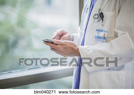 Caucasian doctor using cell phone View Large Photo Image Stock Image - Caucasian doctor using cell phone. Fotosearch