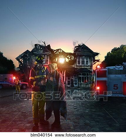 Caucasian firefighter comforting woman at burned house View Large Photo Image Picture - Caucasian firefighter comforting woman at burned house. Fotosearch