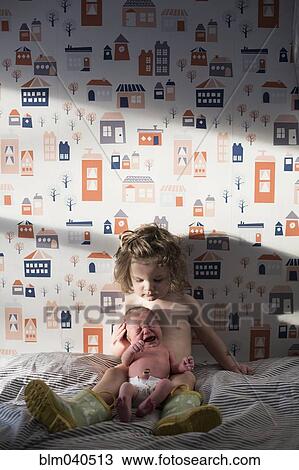 Caucasian girl and newborn baby sister on bed View Large Photo Image Stock Image - Caucasian girl and newborn baby sister on bed. Fotosearch