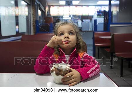 Caucasian girl eating ice cream in cafe View Large Photo Image Stock Image - Caucasian girl eating ice cream in cafe. Fotosearch