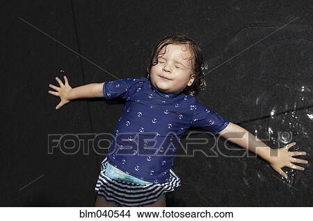 Caucasian girl laying in puddle View Large Photo Image Picture - Caucasian girl laying in puddle. Fotosearch