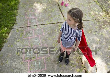 Stock Photo - Caucasian girl playing hopscotch on sidewalk. Fotosearch
