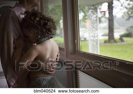 Picture - Caucasian grandmother and granddaughter hugging. Fotosearch
