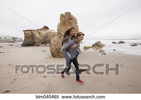 Caucasian man carrying girlfriend piggyback View Large Photo Image Stock Photography - Caucasian man carrying girlfriend piggyback. Fotosearch