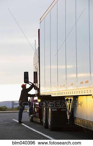 Stock Photograph - Caucasian man climbing into truck. Fotosearch