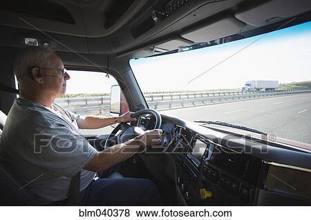 Stock Photo - Caucasian man driving truck on highway. Fotosearch