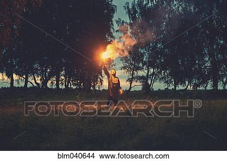 Caucasian man holding torch in field View Large Photo Image Picture - Caucasian man holding torch in field. Fotosearch