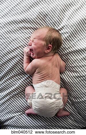 Stock Image - Caucasian newborn baby girl crying. Fotosearch