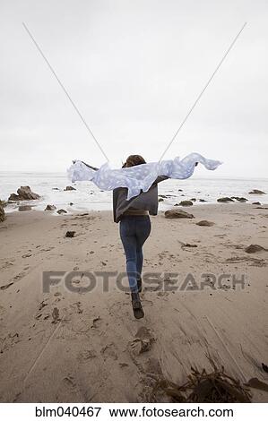 Stock Photo - Caucasian teenage girl playing on beach. Fotosearch