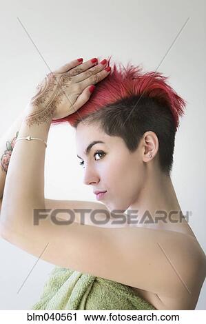 Stock Image - Caucasian woman styling dyed hair. Fotosearch