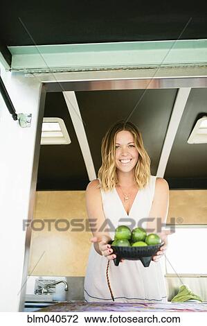 Stock Image - Caucasian woman with bowl of fruit. Fotosearch