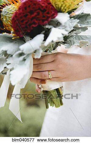 Stock Photo - Close up of bride wearing wedding rings. Fotosearch
