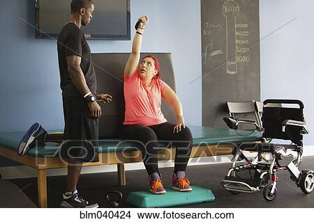 Disabled woman doing physical therapy with trainer View Large Photo Image Picture - Disabled woman doing physical therapy with trainer. Fotosearch