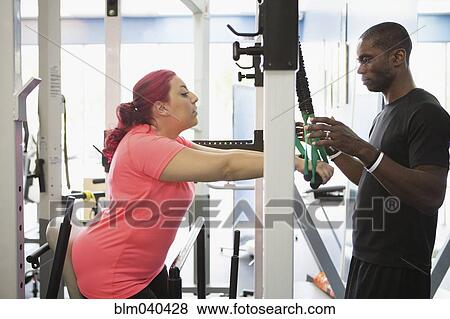 Stock Photo - Disabled woman doing physical therapy with trainer. Fotosearch