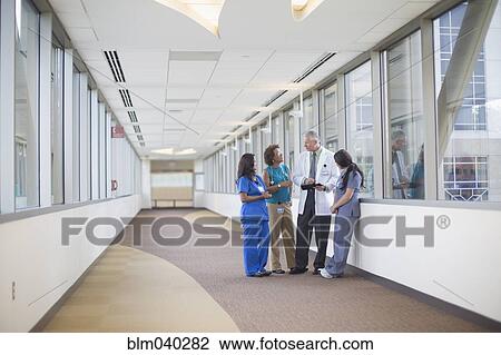 Doctor and nurses talking in hospital hallway View Large Photo Image Stock Image - Doctor and nurses talking in hospital hallway. Fotosearch
