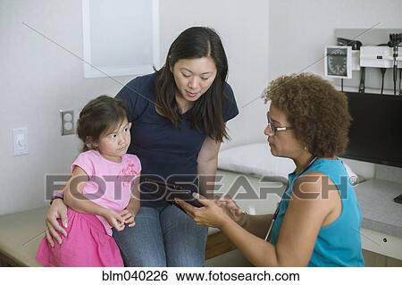 Doctor using digital tablet with patients View Large Photo Image Stock Photograph - Doctor using digital tablet with patients. Fotosearch