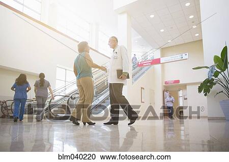 Stock Image - Doctors shaking hands in hospital. Fotosearch