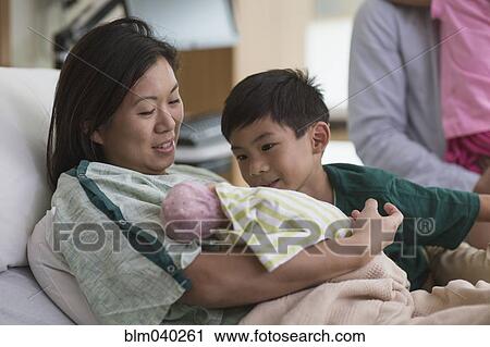 Family admiring newborn baby in hospital room View Large Photo Image Stock Image - Family admiring newborn baby in hospital room. Fotosearch