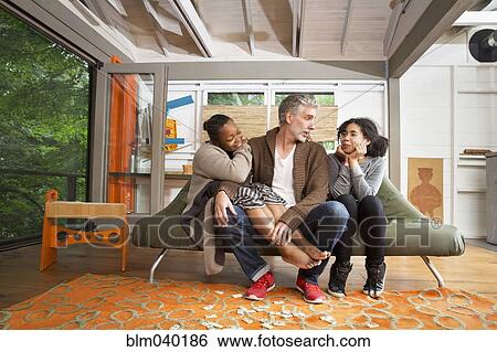 Family hugging in living room View Large Photo Image Stock Photograph - Family hugging in living room. Fotosearch