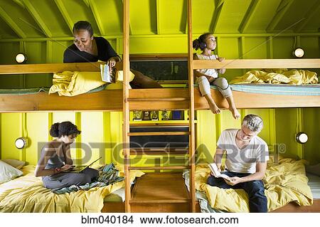 Picture - Family relaxing in bunk beds at camp. Fotosearch