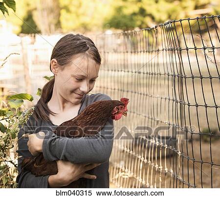 Girl holding chicken on farm View Large Photo Image Stock Photography - Girl holding chicken on farm. Fotosearch