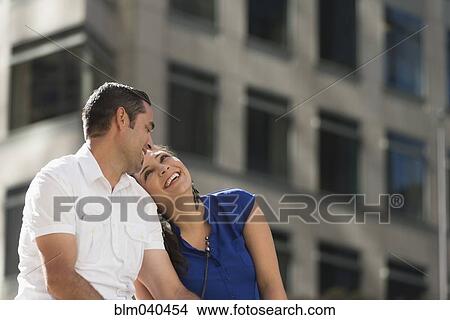 Picture - Hispanic couple hugging in city. Fotosearch