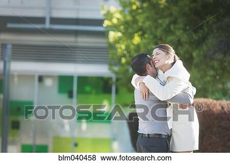Stock Photo - Hispanic couple hugging in city. Fotosearch