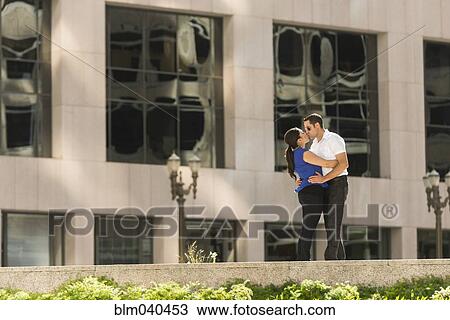 Stock Image - Hispanic couple kissing in city. Fotosearch