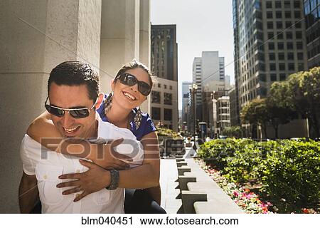 Hispanic man carrying girlfriend piggyback in city View Large Photo Image Stock Image - Hispanic man carrying girlfriend piggyback in city. Fotosearch