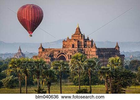 Hot air balloon flying over temple View Large Photo Image Stock Photograph - Hot air balloon flying over temple. Fotosearch