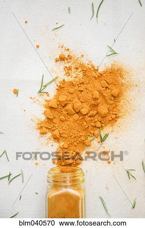 Stock Image - Jar of spilled spices and herbs. Fotosearch