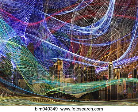 Stock Photo - Light streams over city skyline at night. Fotosearch