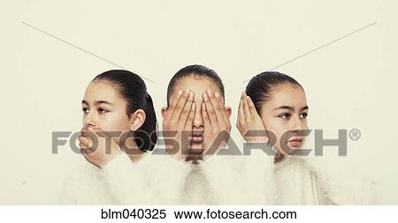 Stock Photography - Mixed race girl covering mouth, eyes and ears. Fotosearch