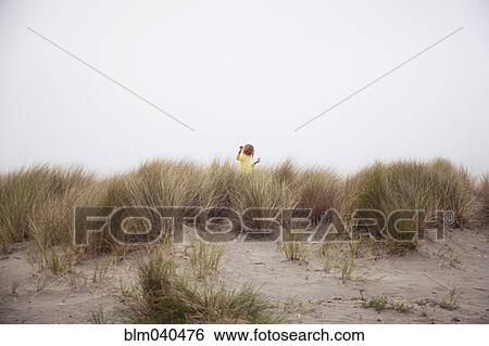 Stock Photograph - Mixed race girl exploring beach. Fotosearch