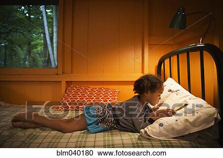 Mixed race girl reading on bed View Large Photo Image Stock Image - Mixed race girl reading on bed. Fotosearch