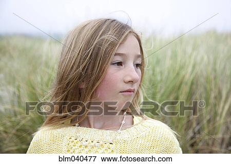 Stock Photo - Mixed race girl standing in grass. Fotosearch
