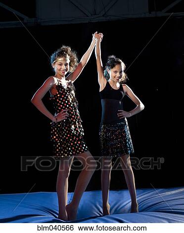 Stock Photograph - Mixed race girls cheering on padding. Fotosearch