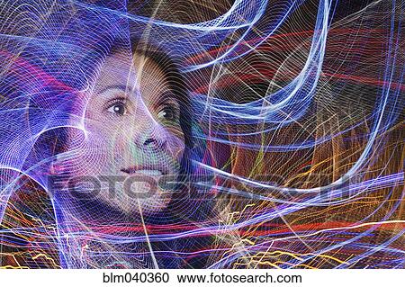 Stock Image - Mixed race woman in light streams. Fotosearch