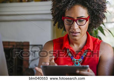 Mixed race woman using digital tablet View Large Photo Image Stock Image - Mixed race woman using digital tablet. Fotosearch