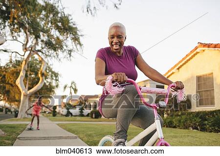 Mother and daughter riding skateboard and bicycle View Large Photo Image Stock Image - Mother and daughter riding skateboard and bicycle. Fotosearch