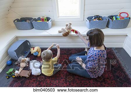 Stock Image - Mother and son playing on floor. Fotosearch