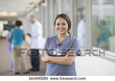 Stock Photography - Nurse smiling in hallway. Fotosearch
