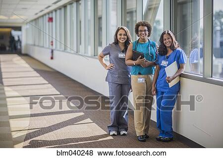 Nurses and doctor smiling in hospital hallway View Large Photo Image Stock Photo - Nurses and doctor smiling in hospital hallway. Fotosearch
