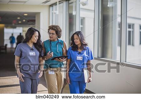 Stock Photo - Nurses and doctor using digital tablet. Fotosearch
