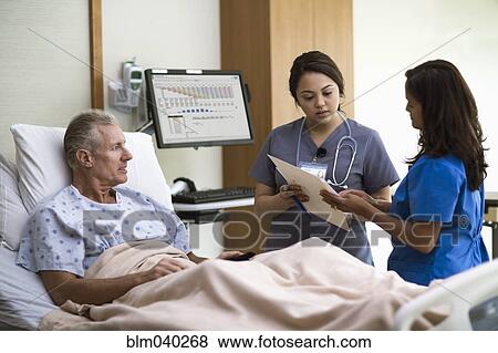 Stock Photo - Nurses and patient talking in hospital room. Fotosearch