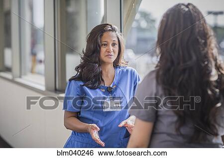 Stock Photograph - Nurses talking in hospital hallway. Fotosearch